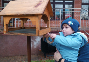 14 Chłopiec zawiesza przysmaki dla ptaszków