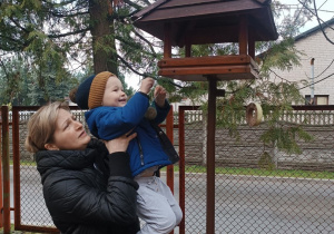 20 Chłopiec sypie ziarenka dla ptaszków