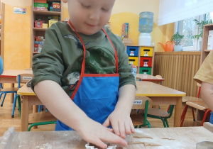 16 Chłopiec przyciska foremkę choinki do ciasta