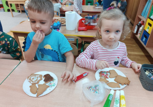 22 Dzieci posypują pierniki posypką