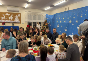 Rodzice z dziećmi na kolacji wigilijnej.