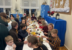 Rodzice z dziećmi na kolacji wigilijnej.