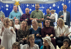 Rodzice z dziećmi wspólnie kolędują "Oj maluśki".