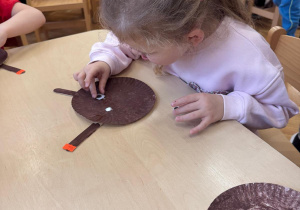 Dziewczynka przykleja oczy.