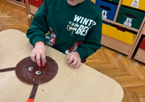 Chłopiec przykleja oczy.