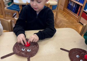 Chłopiec przykleja nos renifera.