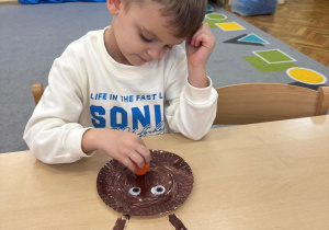 Chłopiec przykleja nos renifera.