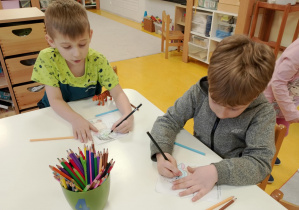 Chłopcy kolorują postać.