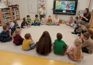 Dzieci słuchają opowiadania o głównym bohaterze.