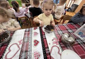 Dziewczynka nabiera herbatę.