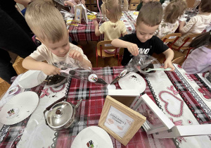 Chłopcy pakują herbatę do woreczków.