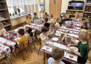 Przedszkolaki jedzą ciasteczka.