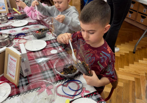 Chłopiec nasypuje herbatkę.