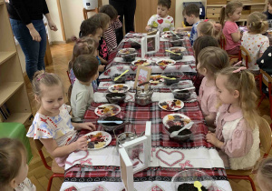 Pani tłumaczy dzieciom jak wykonać mieszankę.