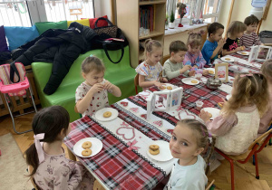 Dzieci przy stole po pracy na warsztatach herbacianych.