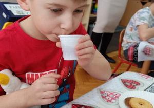 Chłopiec pije harbatkę.