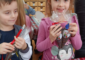 Dzieci pokazują spakowane herbatki dla dziadków.