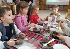Dzieci mieszają herbatę z dodatkami.