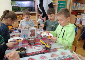 Dzieci wsypują dodatki do herbaty.