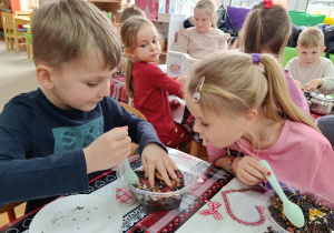 Chłopiec miesza susz herbaciany z dodatkami.