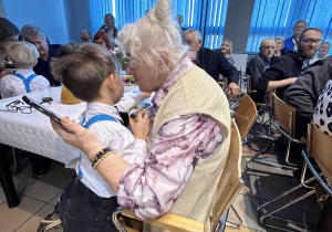 Chłopiec daje prezent babci.