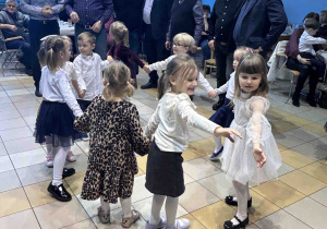 Dzieci tańczą w kółeczku.