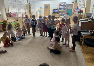 Dzieci z ilustracjami do wysłuchanego opowiadania.