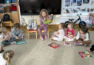 Dziewczynka pokazuje ilustracje - Czerwony Kapturek.