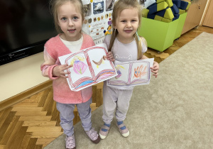 Dziewczynki prezentują swoje namalowane postacie.