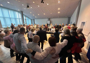 Zabawa w kole z objęciem ramionami przez uczestników.