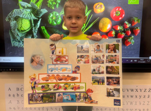 Chłopiec trzyma planszę z piramidą zdrowego żywienia