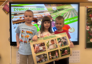 Dzieci pozują z planszą dotyczącą ekologii na co dzień.