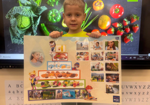 Chłopiec trzyma w ręku planszę z piramidą zdrowego żywienia.