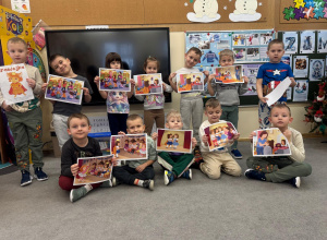 Dzieci pozują z obrazkami dotyczącymi wysłuchanego opowiadania.