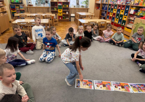Dziewczynka układa historyjkę obrazkową.