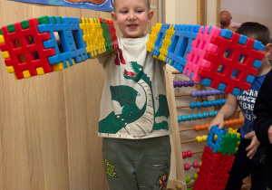 Chłopiec pozuje ze swoją budowlą.