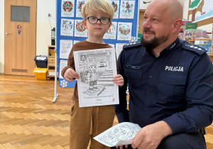 Chłopiec trzyma kolorowankę.