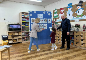 Pani pomaga zawiesić dziewczynce zasady bezpieczeństwa.