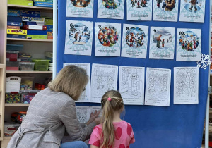 Pani pomaga zawiesić dziewczynce zasady bezpieczeństwa.