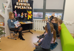 Pani pokazuje dzieciom książkę.