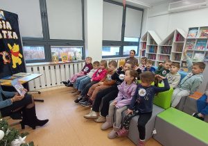 Pani pokazuje dzieciom książkę.