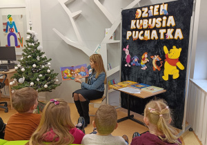 Dzieci słuchają bajki o Kubusiu Puchatku.
