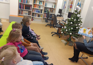 Dzieci słuchają bajki o Kubusiu Puchatku.