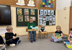 Dziecko siedzi obok Misia i opowiada o swojej ulubionej książce