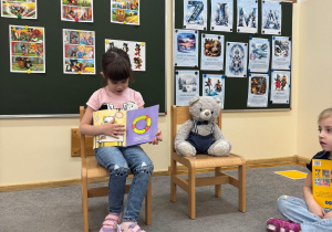 Dziecko z dumą pokazuje swoją ulubioną lekturę.