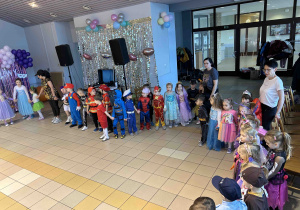 Dzieci tańczą trzymając się za rączki.