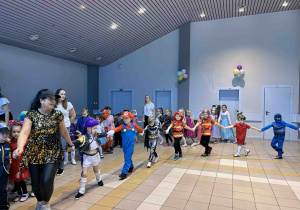 Pani animatorka prowadzi dzieci.