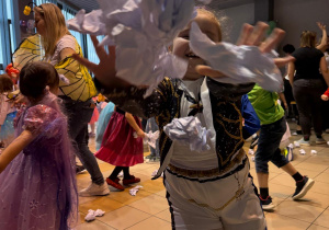 Dziewczynka rzuca papierowymi śnieżkami.