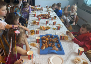 Dzieci jedzą słodki poczęstunek.