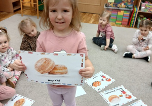 10. Dziewczynka trzyma zdjęcie pączków.